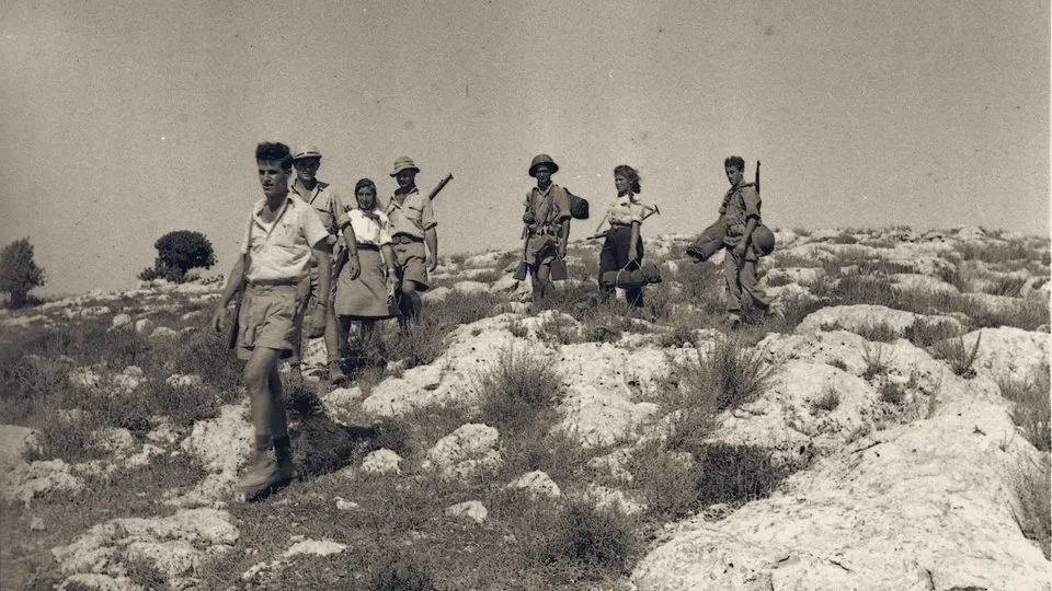 A Palmach squad walks across the rocky slopes to the Israeli positions facing Latrun, 1948.